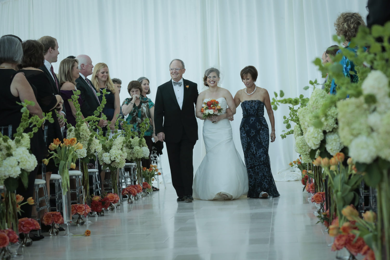 Bride walking down aisle by parents
